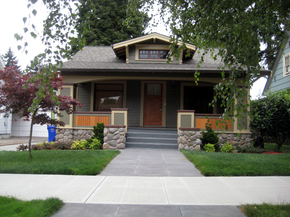 Esempio della facciata di una casa piccola american style a un piano con rivestimento con lastre in cemento