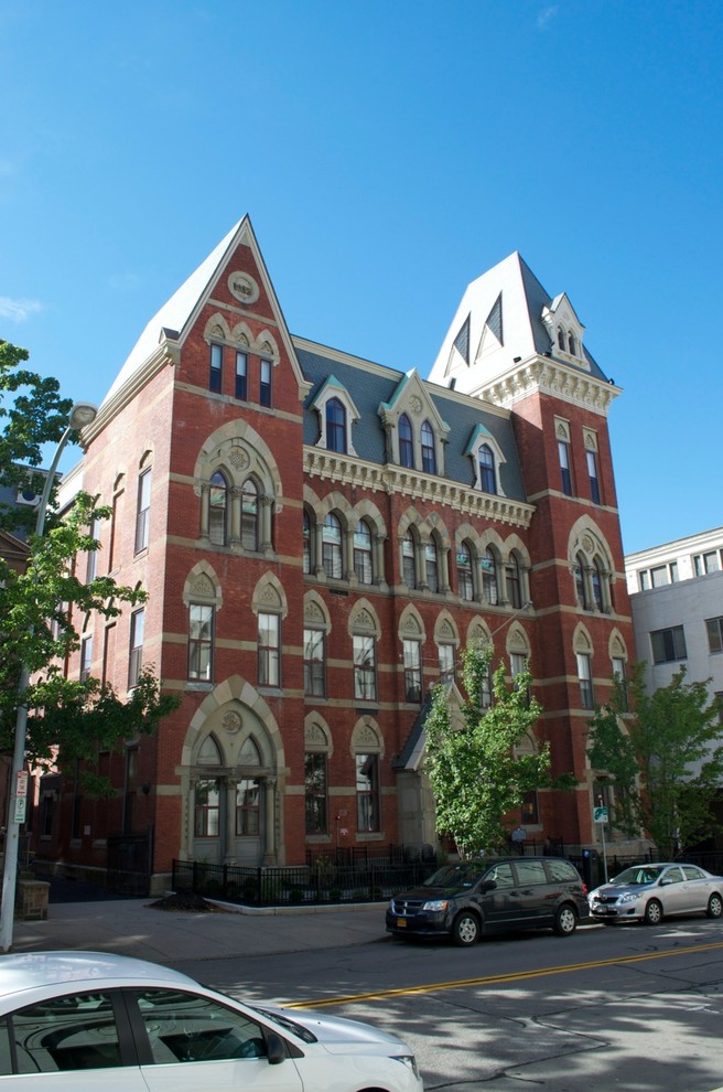Example of a huge ornate red three-story brick apartment exterior design in New York
