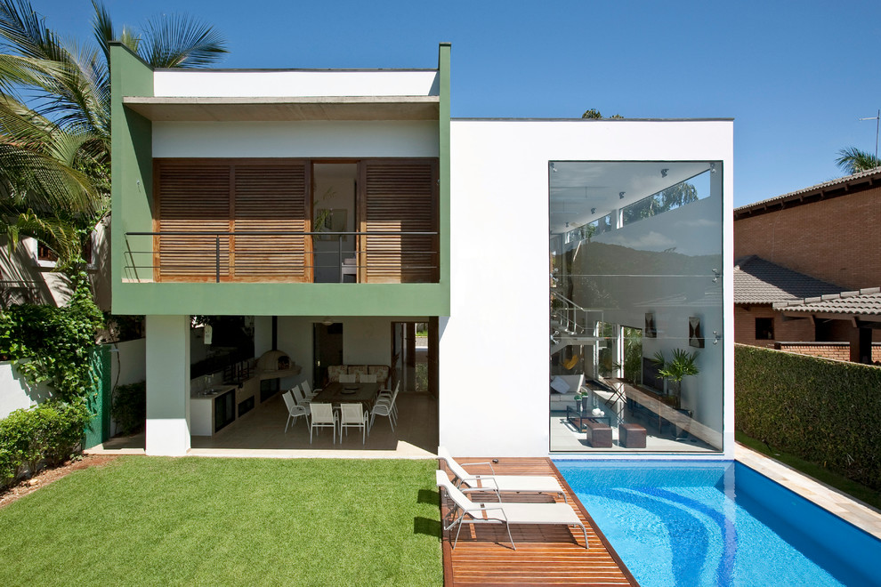 Modelo de fachada verde contemporánea de dos plantas con revestimientos combinados y tejado plano