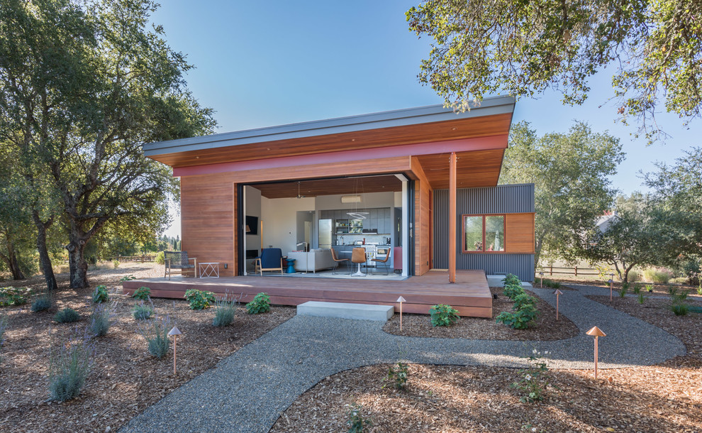 Cette photo montre une façade de maison multicolore tendance de plain-pied avec un revêtement mixte et un toit en appentis.