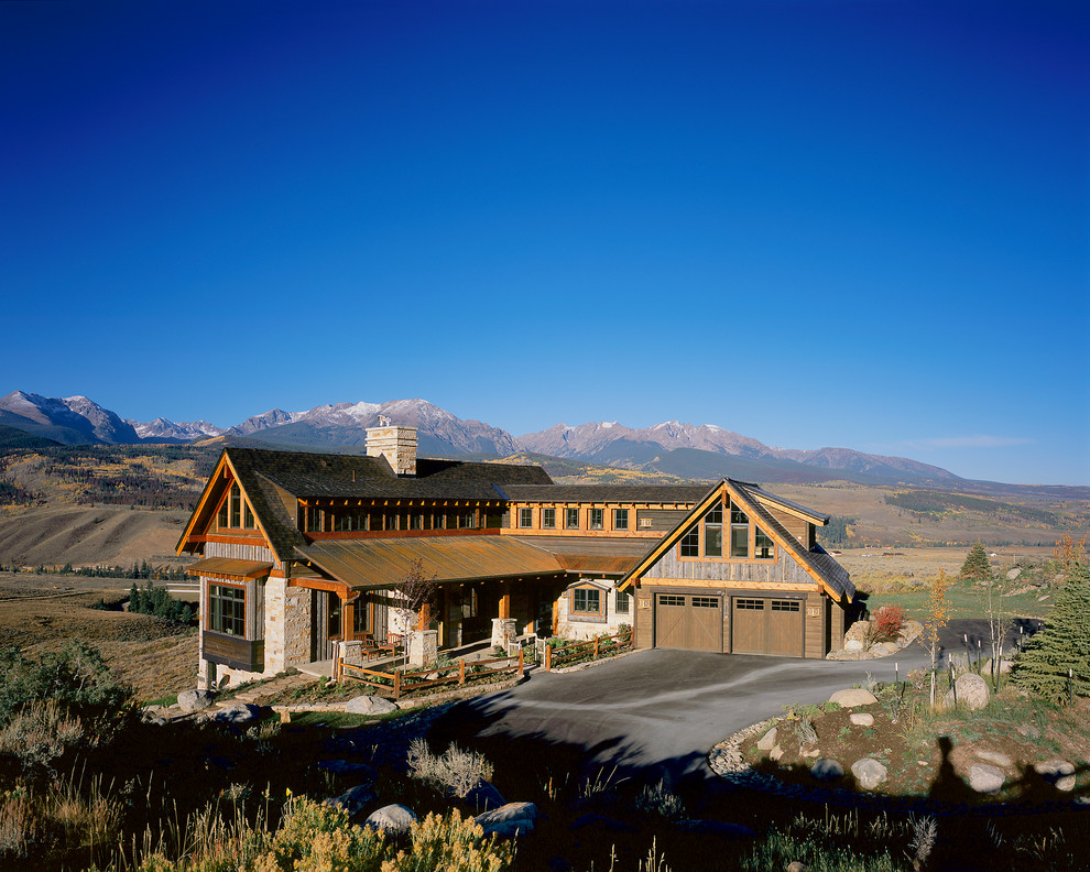 This is an example of a large rustic two floor house exterior in Denver with mixed cladding and a pitched roof.