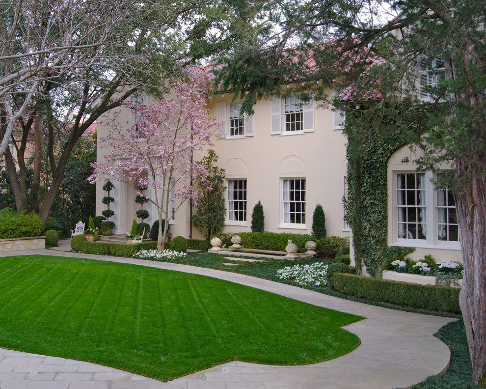 Diseño de fachada de casa beige clásica grande de dos plantas con revestimiento de estuco, tejado a dos aguas y tejado de teja de barro