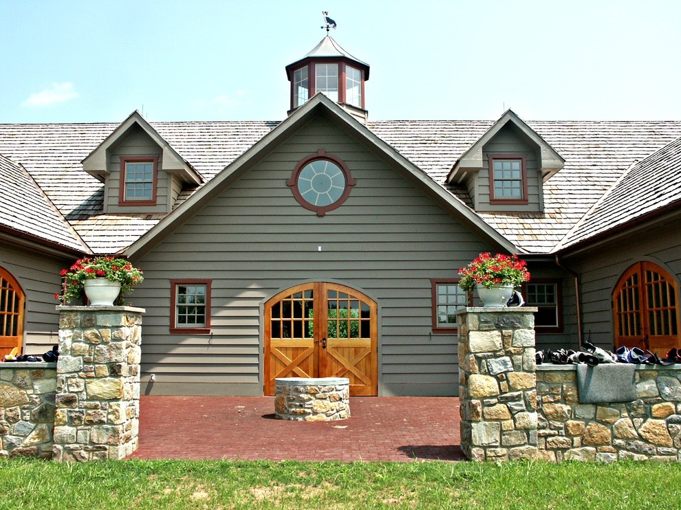 На фото: двухэтажный, серый дом среднего размера в стиле кантри с двускатной крышей и комбинированной облицовкой