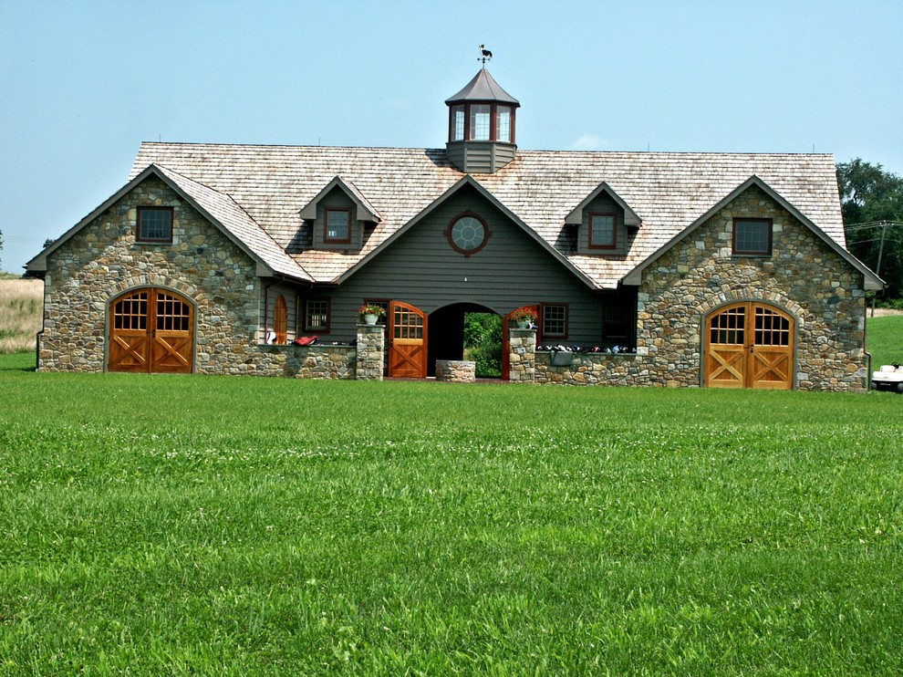 Ejemplo de fachada gris campestre de tamaño medio de dos plantas con tejado a dos aguas y revestimientos combinados
