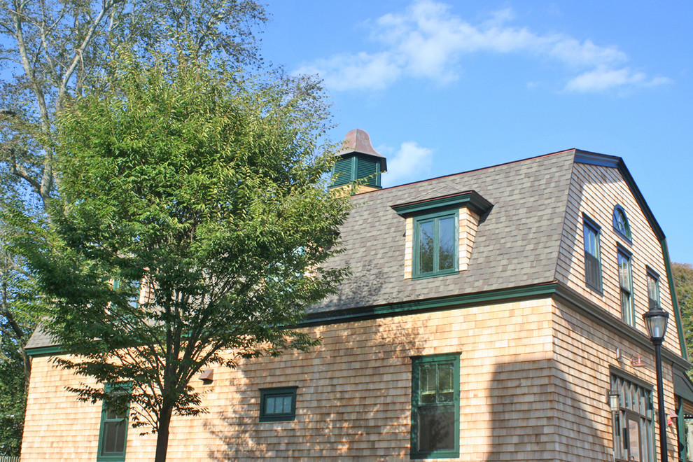 Ejemplo de fachada marrón clásica grande de dos plantas con revestimiento de madera y tejado a doble faldón