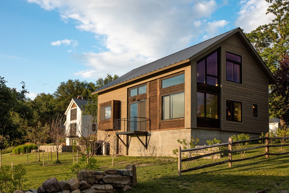 На фото: двухэтажный, разноцветный частный загородный дом среднего размера в стиле рустика с комбинированной облицовкой, двускатной крышей и металлической крышей с