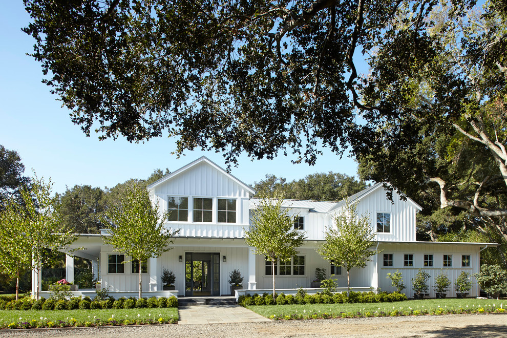 Cette image montre une grande façade de maison blanche design en bois à un étage.
