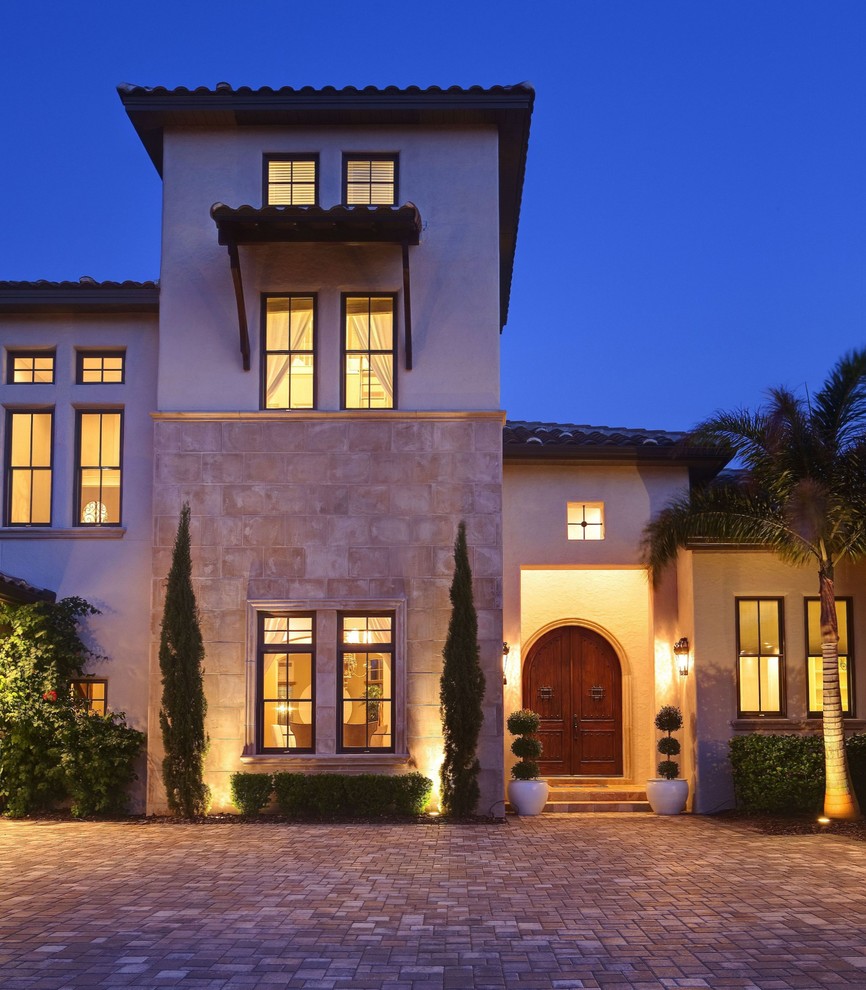 Inspiration for a mediterranean render house exterior in Orlando with three floors.