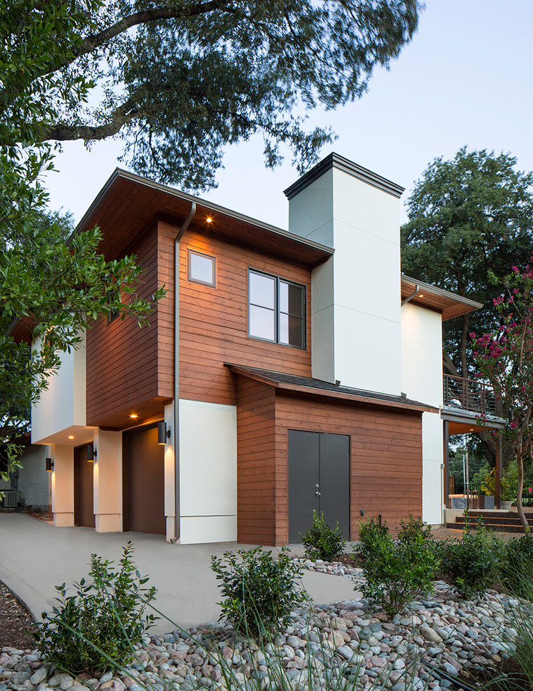 Foto della villa grande marrone contemporanea a due piani con rivestimento in legno, tetto a padiglione e copertura mista