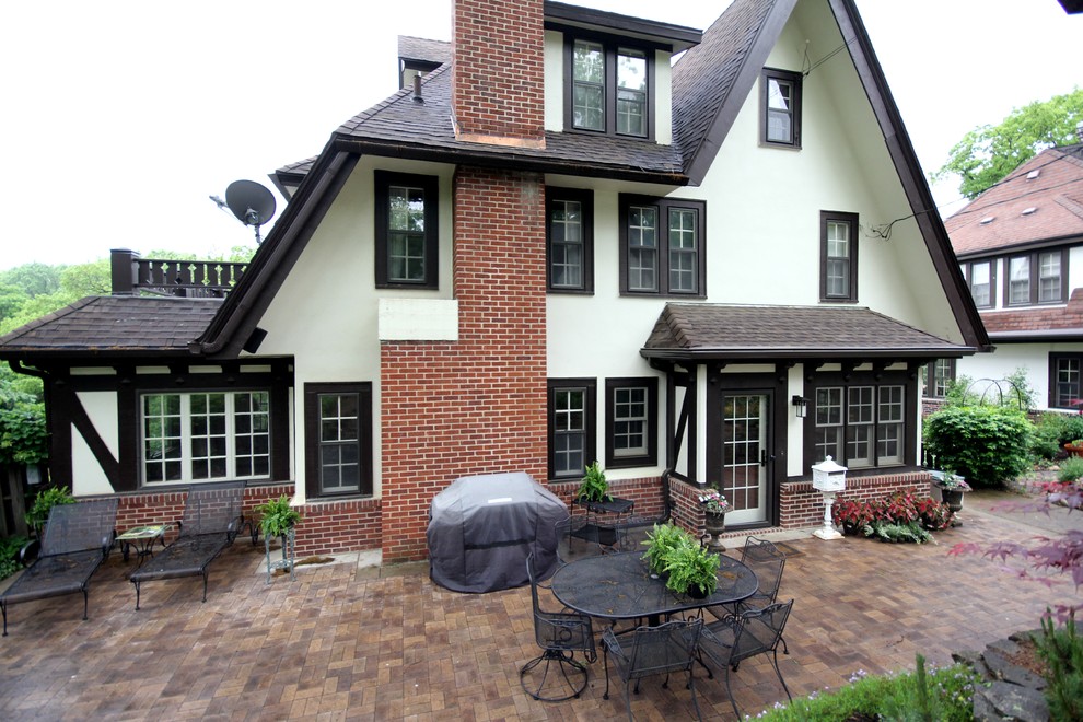 Imagen de fachada blanca tradicional de tamaño medio de tres plantas con revestimientos combinados y tejado a dos aguas