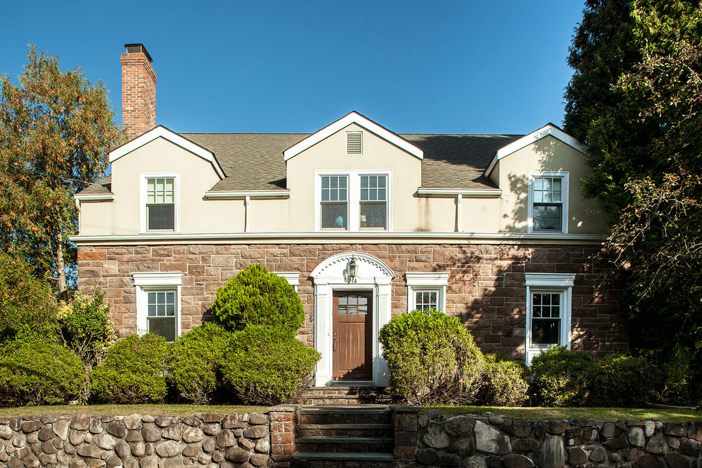 Пример оригинального дизайна: двухэтажный, бежевый дом в классическом стиле с облицовкой из цементной штукатурки и односкатной крышей