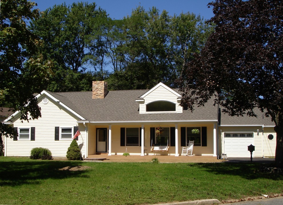 Exemple d'une façade de maison beige nature de taille moyenne et de plain-pied avec un revêtement en vinyle et un toit à deux pans.