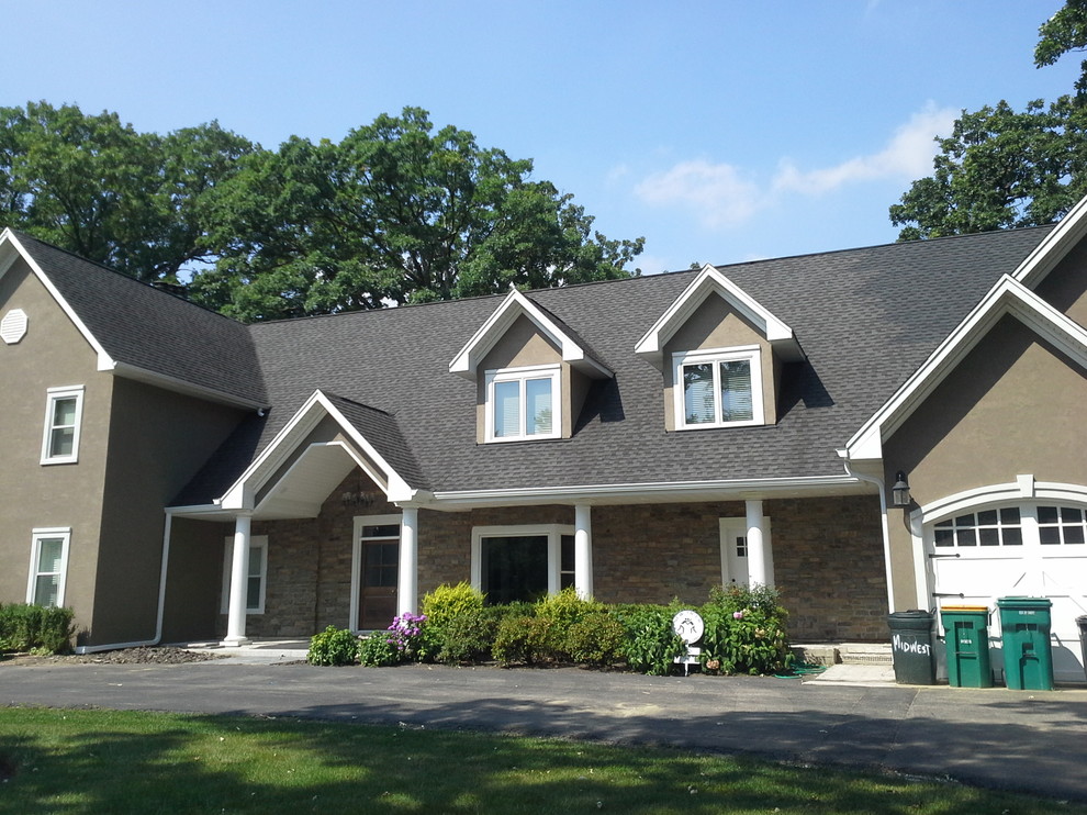 Photo of a large and brown classic two floor render detached house in Chicago with a pitched roof and a shingle roof.