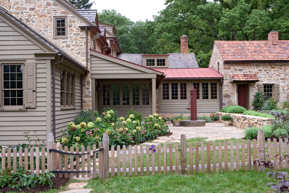 Inspiration for a mid-sized farmhouse brown two-story mixed siding exterior home remodel in Philadelphia with a mixed material roof and a red roof