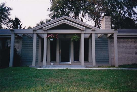 Cette image montre une petite façade de maison grise traditionnelle de plain-pied avec un revêtement mixte.