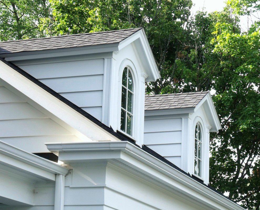 Imagen de fachada blanca de estilo de casa de campo de tamaño medio de dos plantas con revestimiento de vinilo y tejado a dos aguas