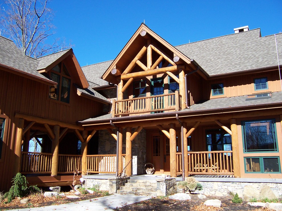 Ejemplo de fachada de casa marrón rural grande de tres plantas con revestimiento de madera, tejado a dos aguas y tejado de teja de madera