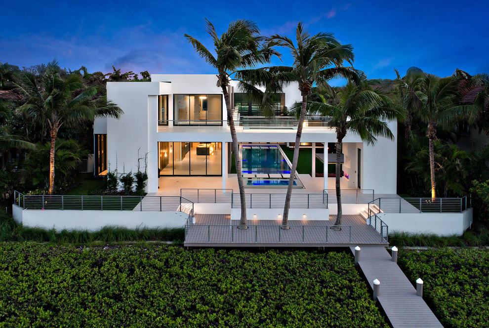 White beach style two floor detached house in Miami with a flat roof.