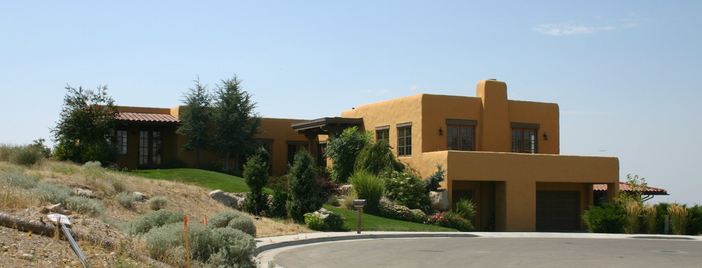 Inspiration for a mediterranean yellow adobe exterior home remodel in Boise