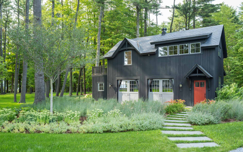 Imagen de fachada de casa negra rural de dos plantas con tejado a dos aguas y tejado de teja de madera