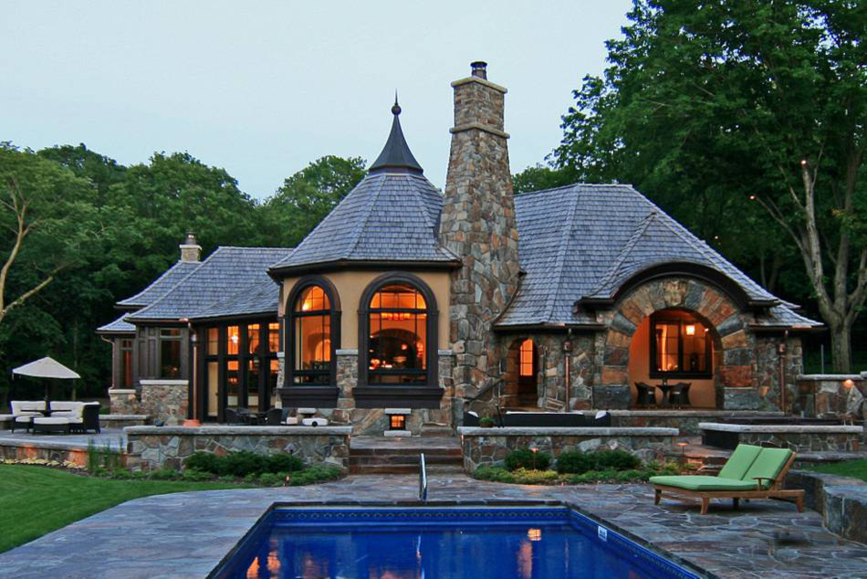 Idée de décoration pour une grande façade de maison beige chalet en pierre à un étage avec un toit en shingle.
