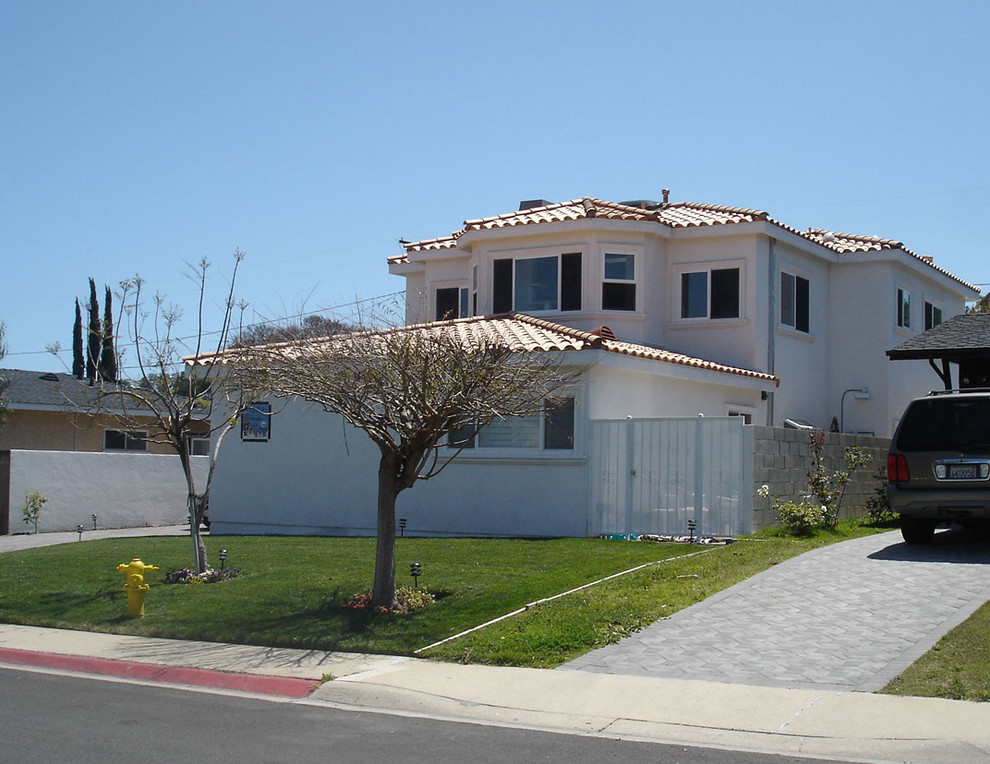 На фото: двухэтажный, белый частный загородный дом среднего размера в средиземноморском стиле с облицовкой из цементной штукатурки, вальмовой крышей и черепичной крышей