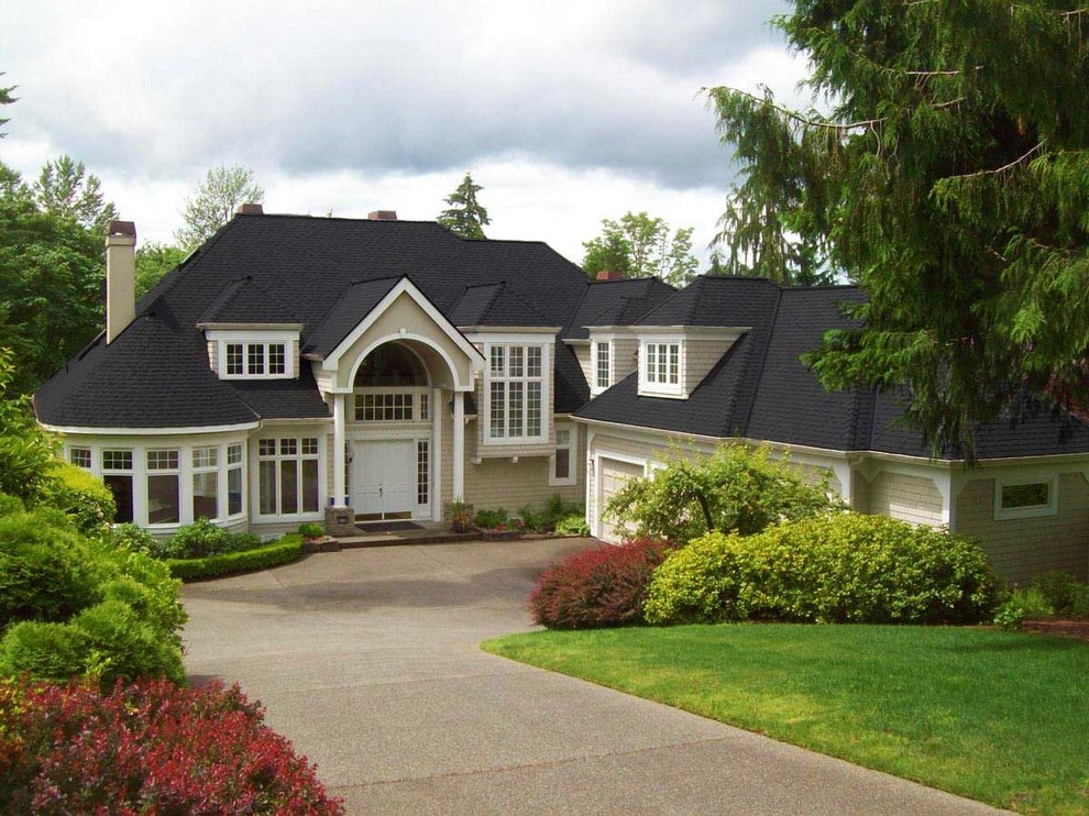 Inspiration for a large timeless beige two-story house exterior remodel in Seattle with a hip roof and a shingle roof