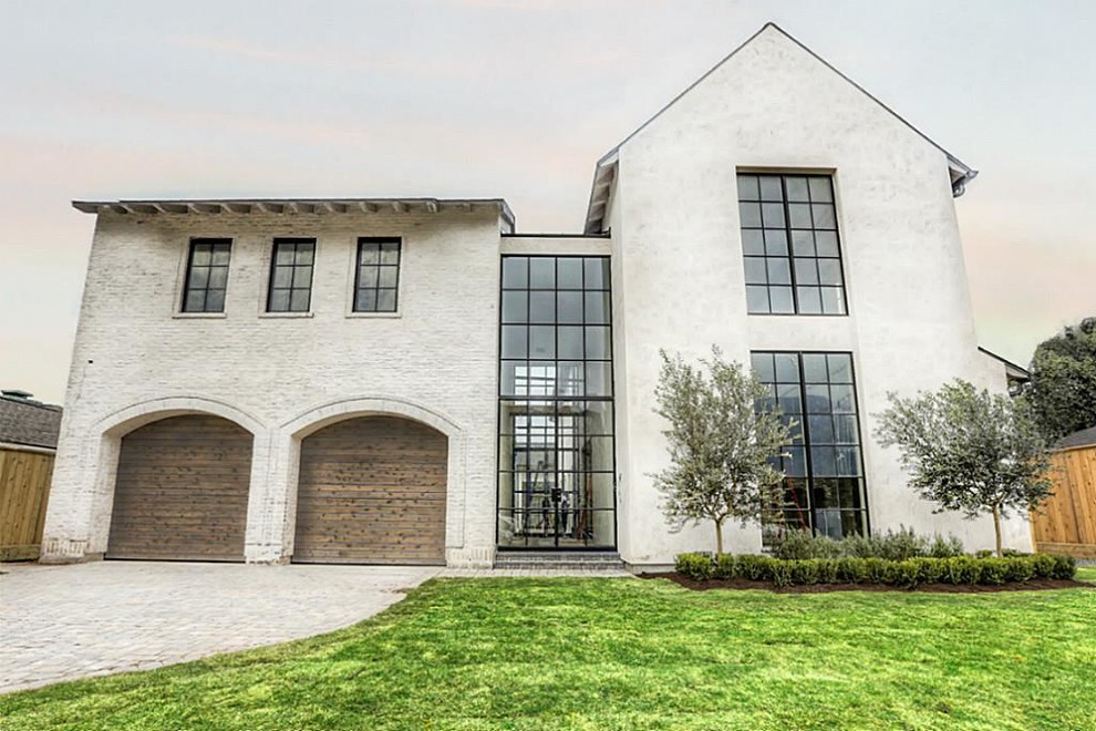 Large and white traditional two floor house exterior in Houston with mixed cladding and a pitched roof.
