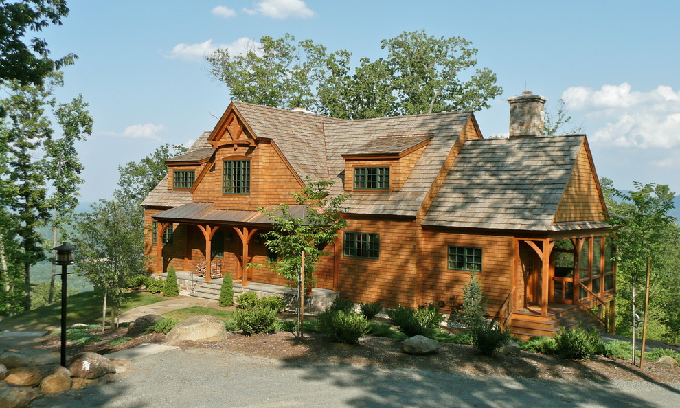 Aménagement d'une grande façade de maison marron montagne en bois à deux étages et plus.