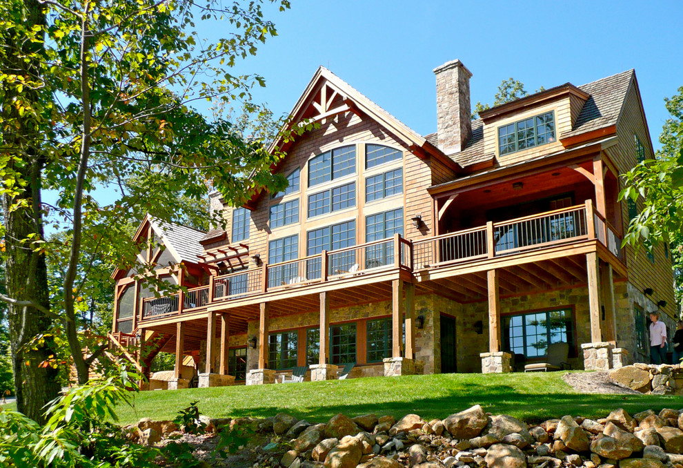 Cette image montre une grande façade de maison marron chalet en bois à un étage.