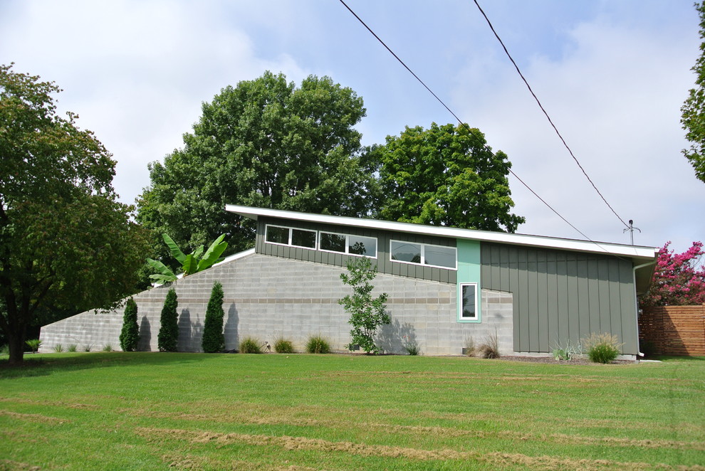 Exemple d'une façade de maison grise rétro de taille moyenne et de plain-pied avec un revêtement mixte et un toit en appentis.