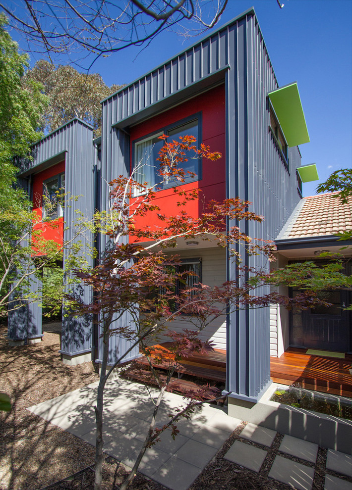 На фото: маленький, двухэтажный, синий дом в современном стиле с облицовкой из металла и плоской крышей для на участке и в саду