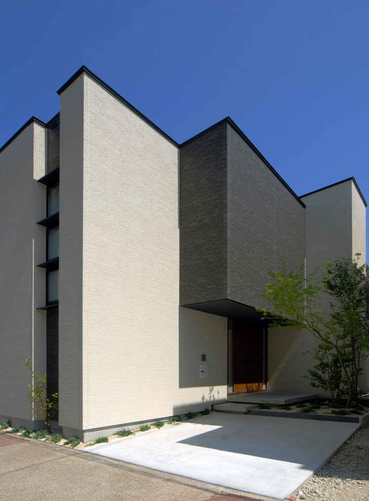 Modern inredning av ett beige hus, med två våningar, blandad fasad och platt tak