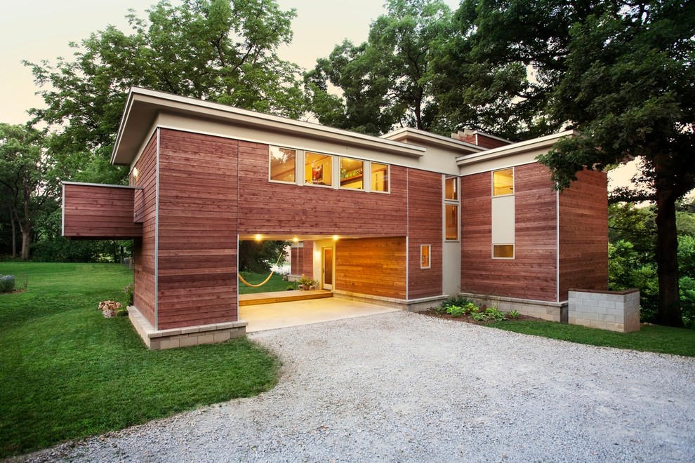 На фото: двухэтажный, деревянный, большой, коричневый частный загородный дом в стиле модернизм с плоской крышей с