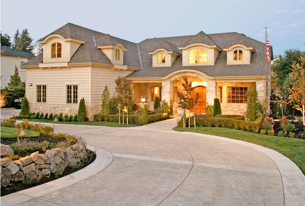Exemple d'une grande façade de maison beige chic à un étage avec un revêtement mixte et un toit à croupette.