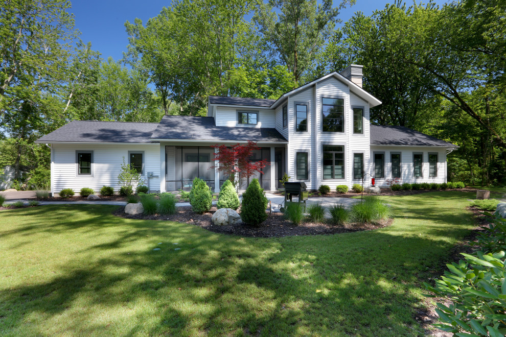 Mittelgroßes, Zweistöckiges Landhaus Einfamilienhaus mit Vinylfassade, weißer Fassadenfarbe, Satteldach und Schindeldach in Grand Rapids