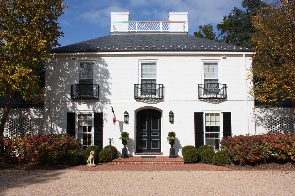 Elegant white two-story exterior home photo in Other with a hip roof