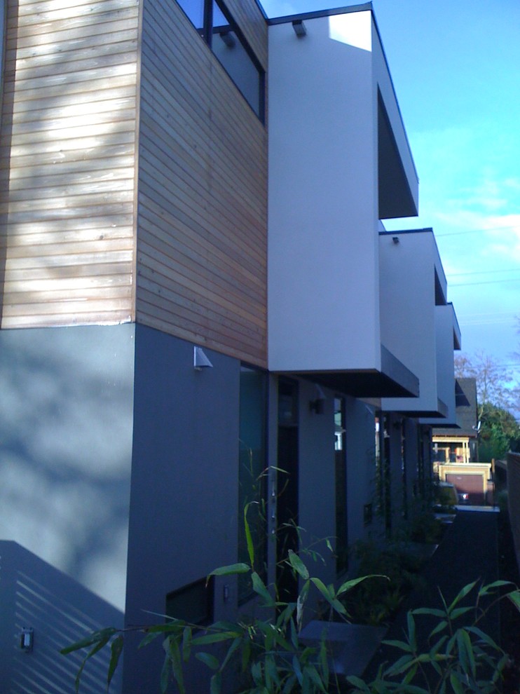 Foto della facciata di una casa moderna a tre piani con rivestimento in stucco