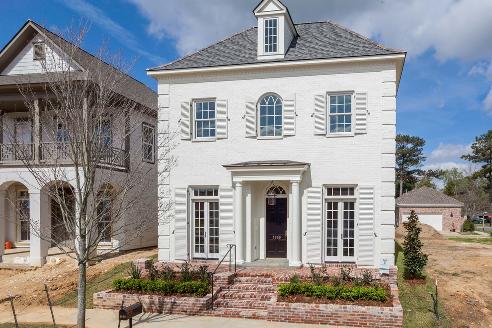 Inspiration for a medium sized and white classic two floor brick house exterior in New Orleans with a pitched roof.