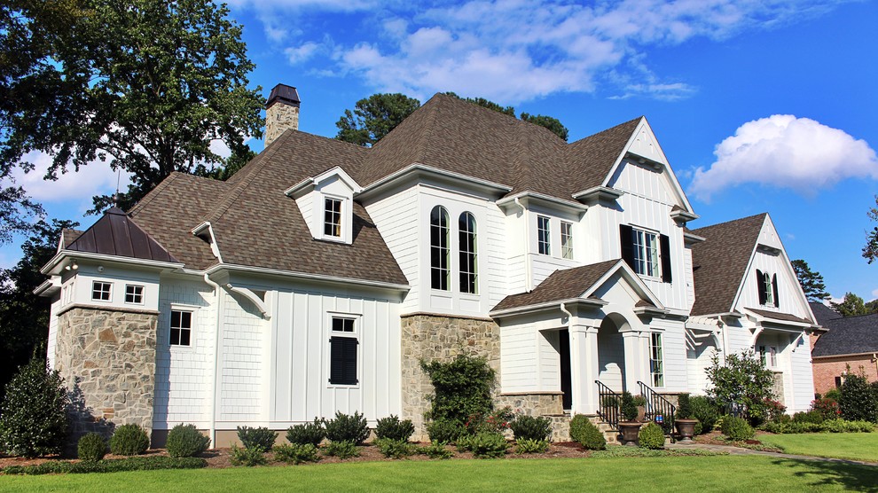 Идея дизайна: большой, двухэтажный, белый дом в стиле фьюжн с комбинированной облицовкой и вальмовой крышей
