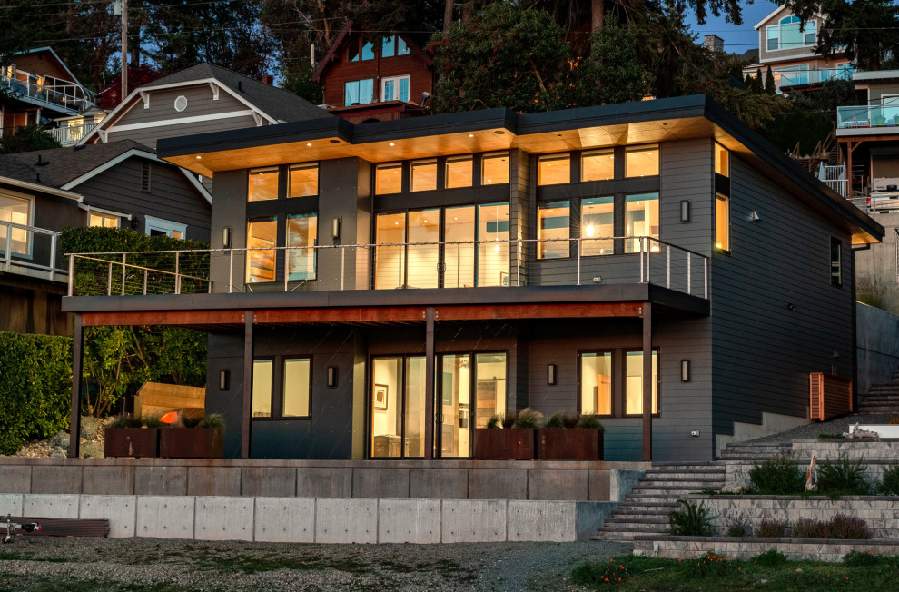Diseño de fachada de casa gris moderna grande de dos plantas con revestimiento de aglomerado de cemento, tejado de un solo tendido y tejado de metal