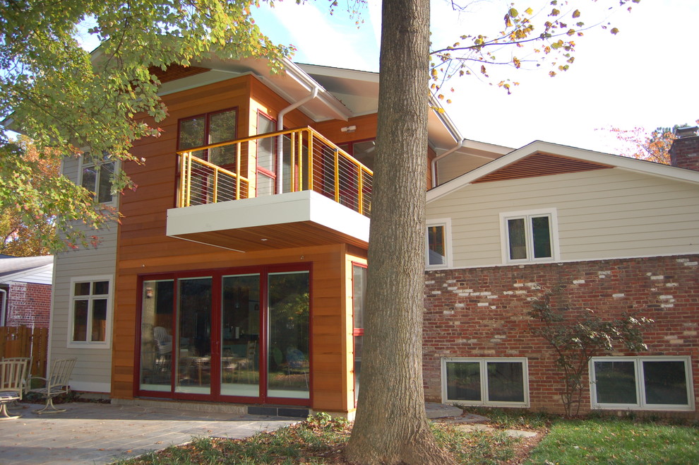 Aménagement d'une façade de maison beige contemporaine de taille moyenne et à un étage avec un toit à deux pans et un revêtement mixte.