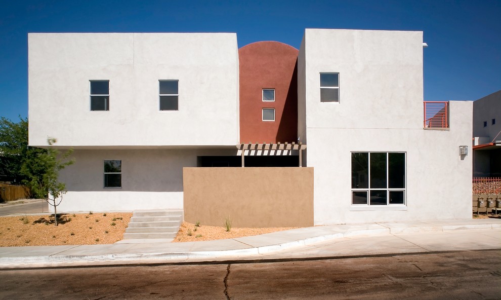 Cette image montre une petite façade de maison design en stuc à un étage.