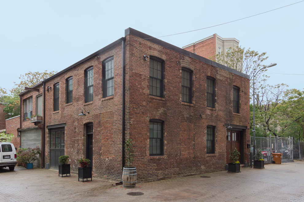 Imagen de fachada de casa marrón urbana grande de dos plantas con revestimiento de ladrillo y tejado plano