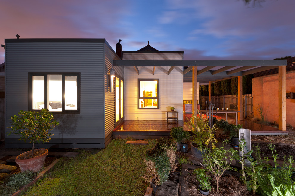 Cette photo montre une petite façade de maison métallique et grise éclectique de plain-pied avec un toit plat.