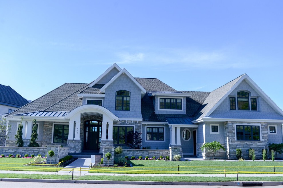Cette photo montre une grande façade de maison grise moderne en bois à deux étages et plus avec un toit à deux pans.