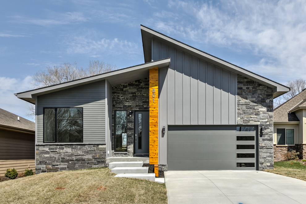 На фото: одноэтажный, серый частный загородный дом в современном стиле с комбинированной облицовкой и односкатной крышей