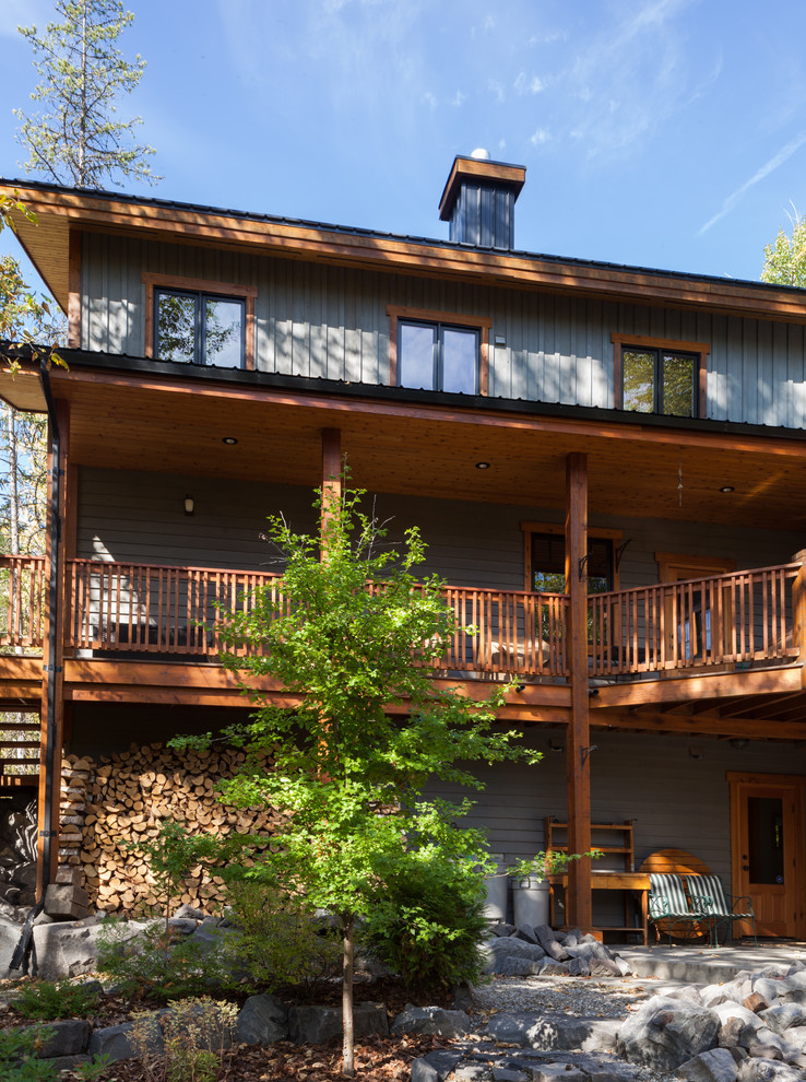 Aménagement d'une façade de maison grise montagne en bois de taille moyenne et à un étage avec un toit à deux pans.