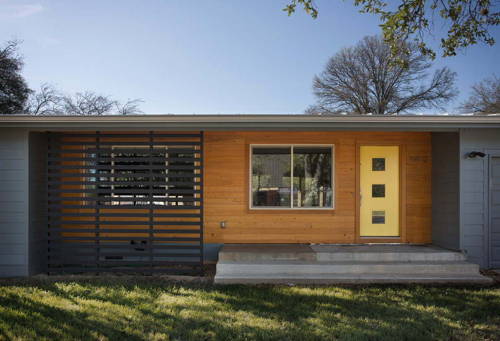 Mid-century modern gray one-story wood flat roof idea in Austin