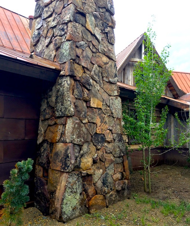 Modelo de fachada de casa rústica grande de dos plantas con revestimiento de piedra